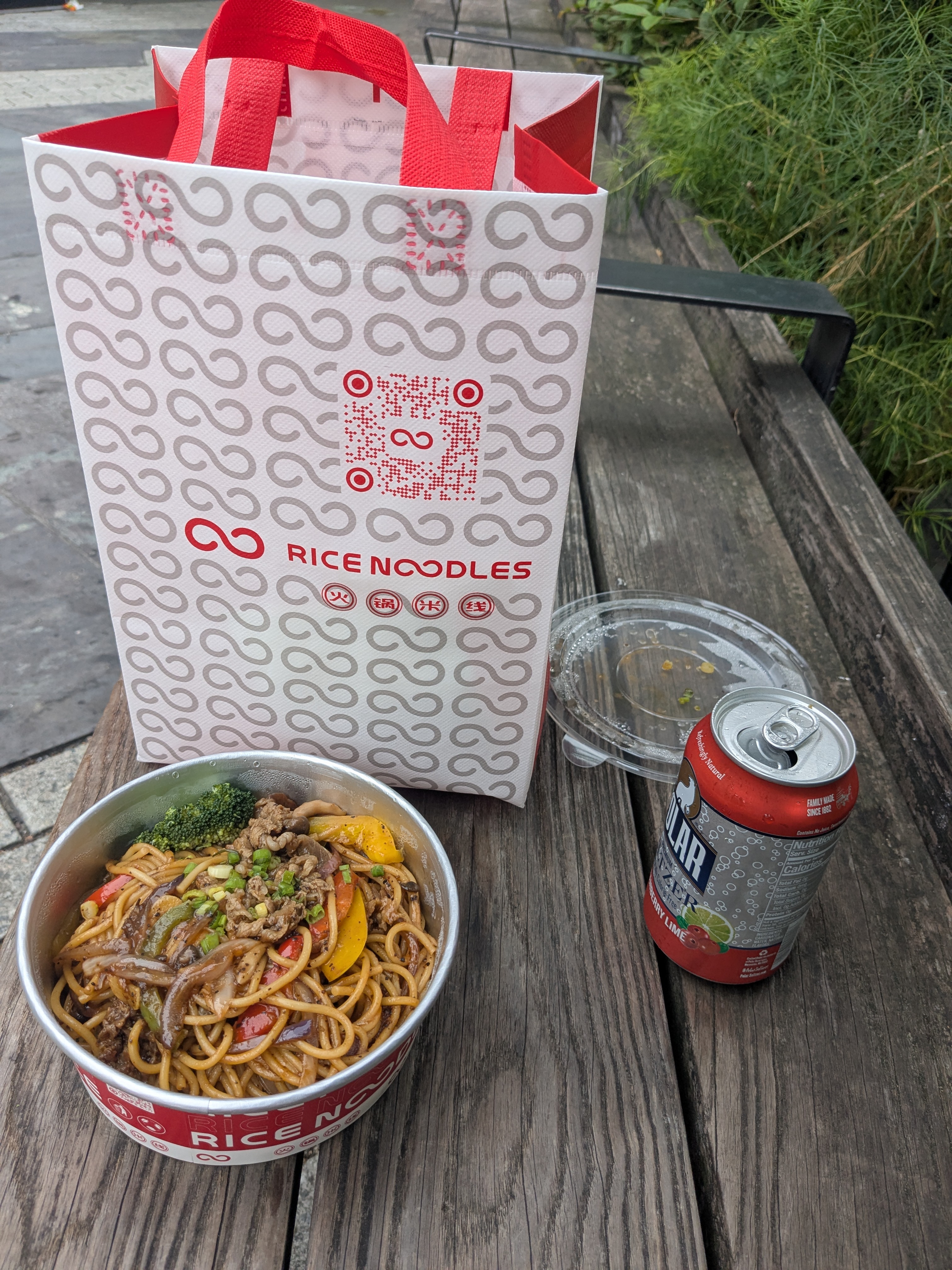Black pepper beef pasta and a polar seltzer on a bench